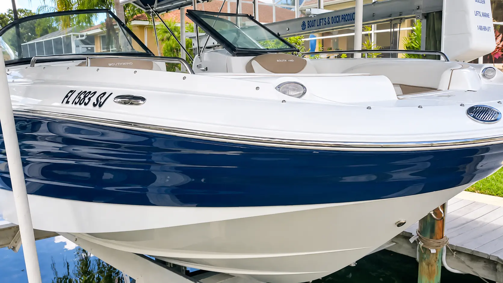 White and navy Southwind boat with registration number displayed at dock